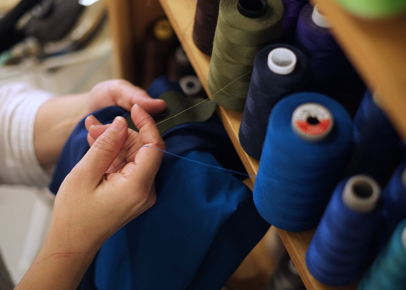 A close-up photo of hands unravelling thread.