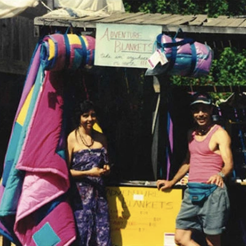 A photo of Robbin and Angeline Lacy in front of a stand advertising the original Adventure Blanket.