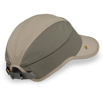 A multi-panel outdoor cap in beige and gray-green, featuring a curved brim, a small gold button on the side, and an adjustable mesh back strap.